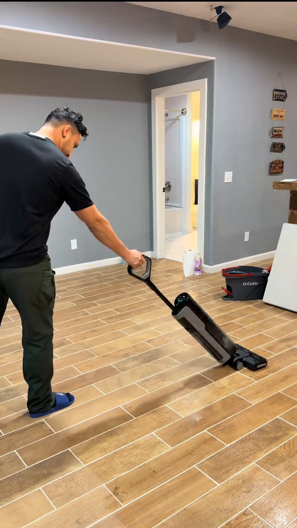 Persona usando la aspiradora inalámbrica en piso de madera