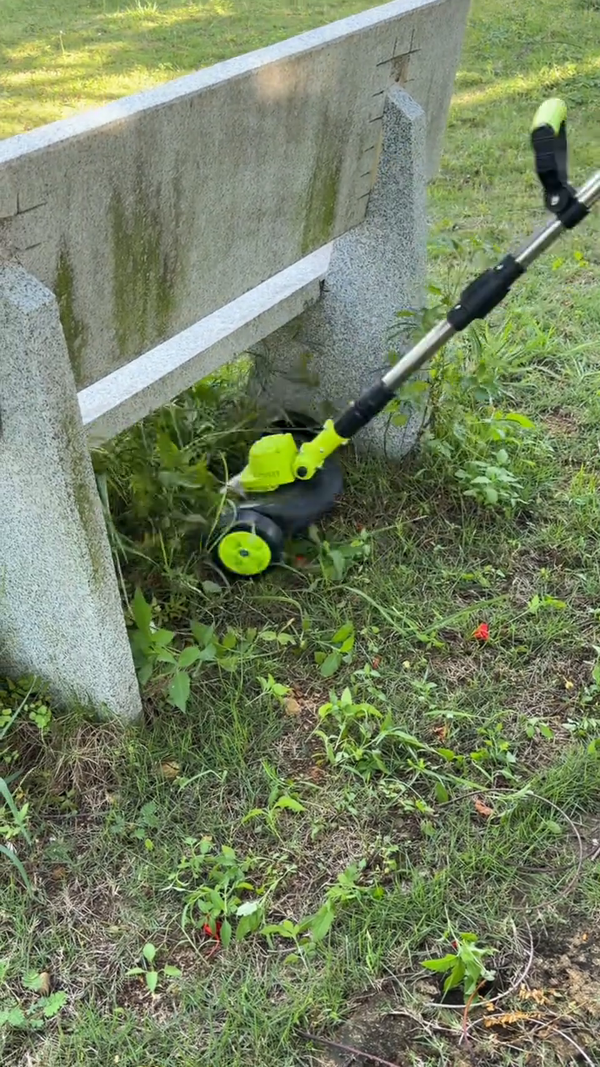 Podadora inalámbrica limpiando orillas debajo de un banco de jardín