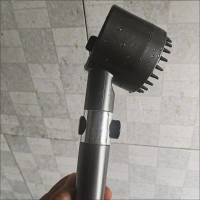 Ducha masajeadora negra instalada en el baño
