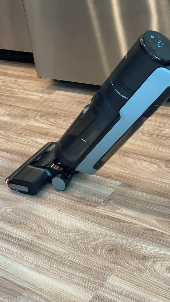 Aspiradora inalámbrica vertical lista para usar sobre piso de madera