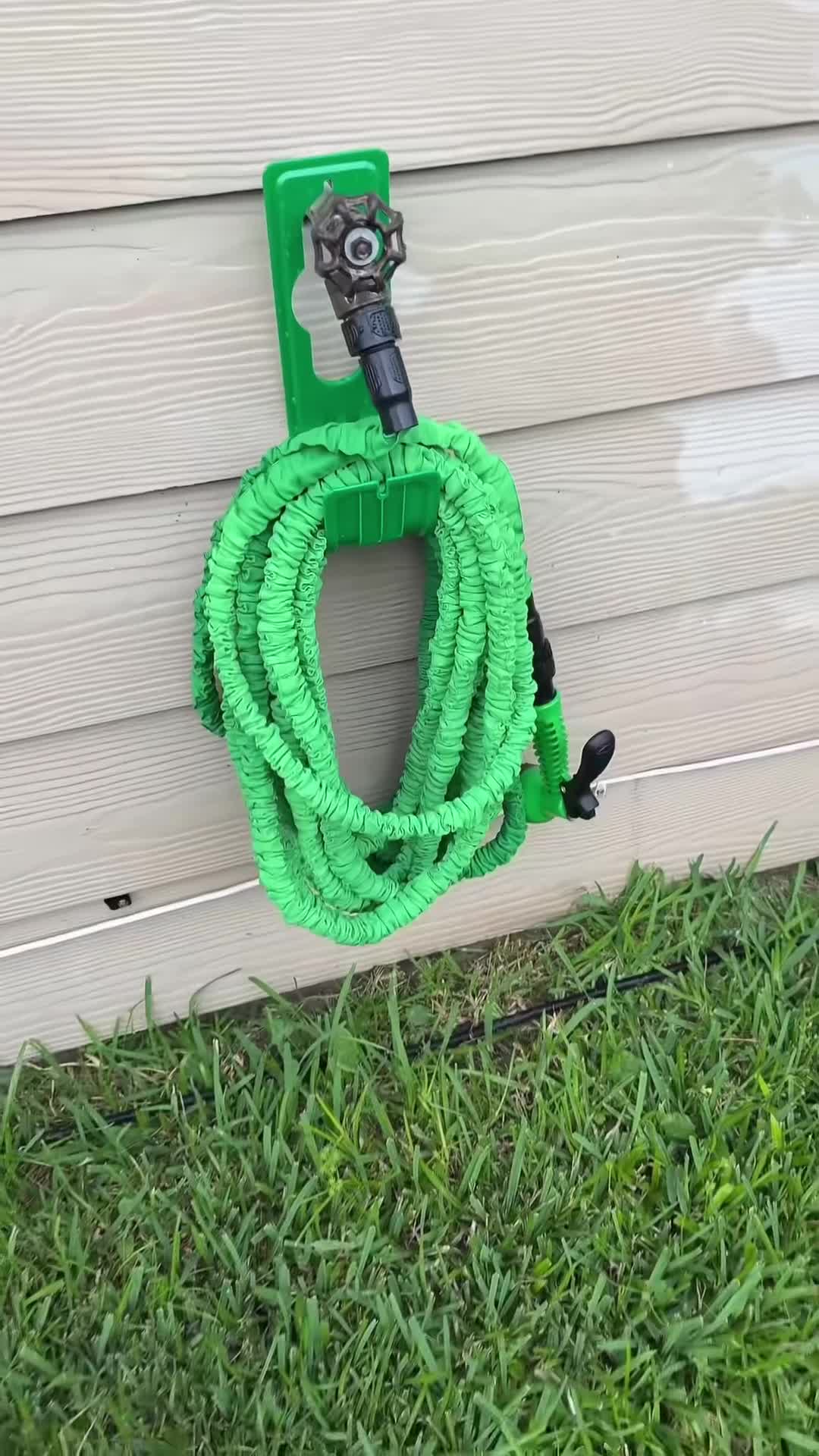 Manguera contraida colgada de un gancho en la pared