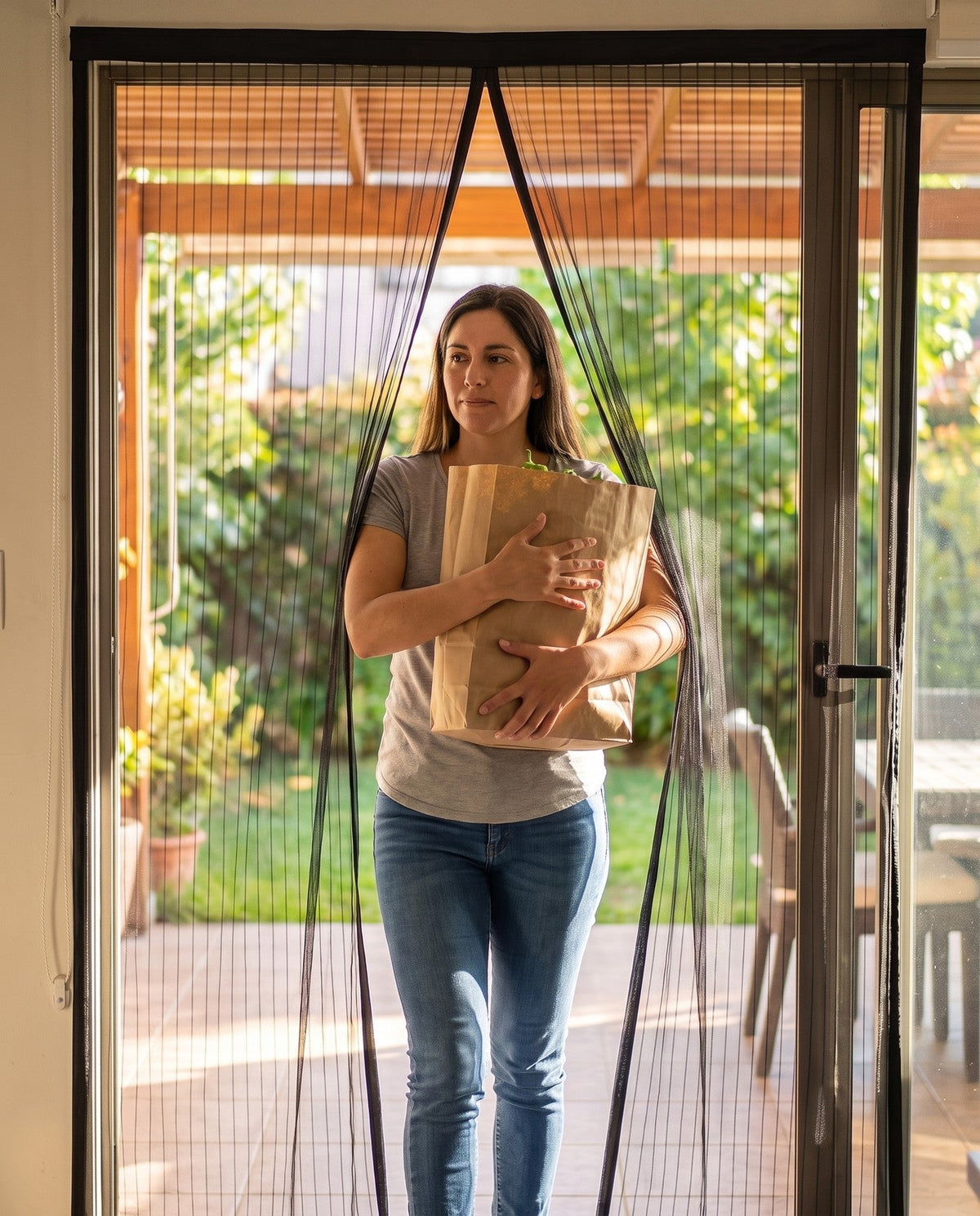 Mujer entrando con las manos llenas por la malla magnetica