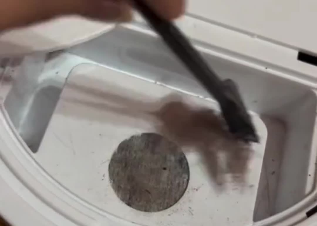 Deposito del robot lleno de pelusa y pelos recogidos del piso